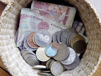 Ein Flechtkorb mit alten europäischen Münzen und Geldscheinen darin