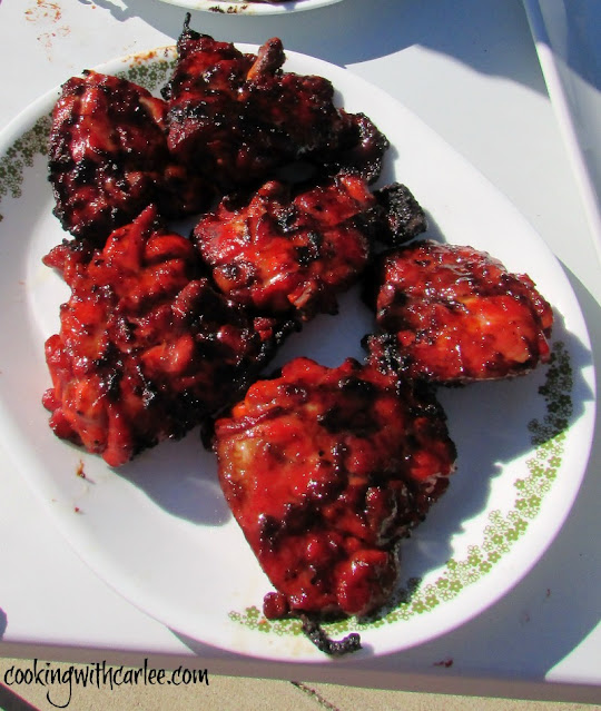 This fun grilled chicken recipe is based of char siu, the red pork you see at Chinese restaurants. It soaks for a long time in a great marinade giving it that color and tons of flavorful. bright red grilled chicken on small platter