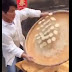 Baker throws pieces of dough in the air, catches it using a different tray without losing its formation