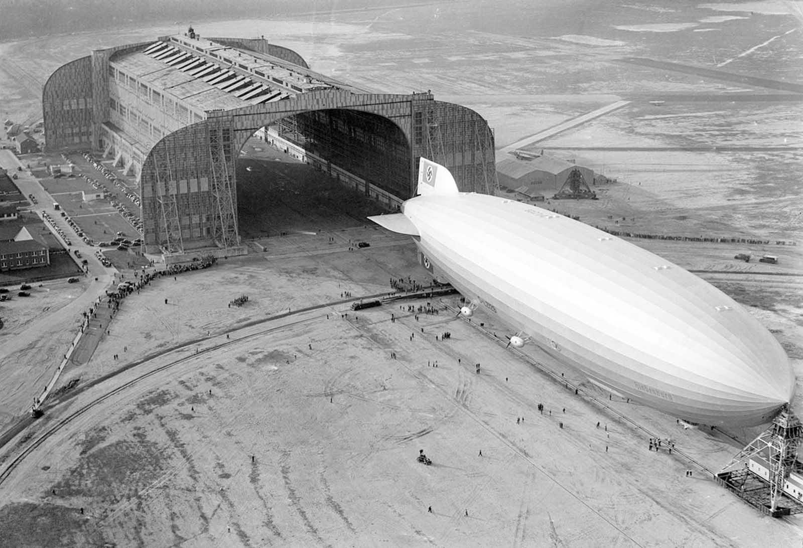 The German-built zeppelin Hindenburg trundles into the U.S. Navy hangar, its nose hooked to the mobile mooring tower, at Lakehurst, New Jersey, on May 9, 1936. The rigid airship had just set a record for its first north Atlantic crossing, the first leg of ten scheduled round trips between Germany and America.