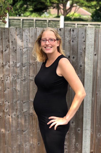 Me in a black dress with a 20 week bump which is now slightly bigger than my boobs