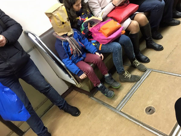 Papiertüte über Kopf - lustiges Kind in Straßenbahn