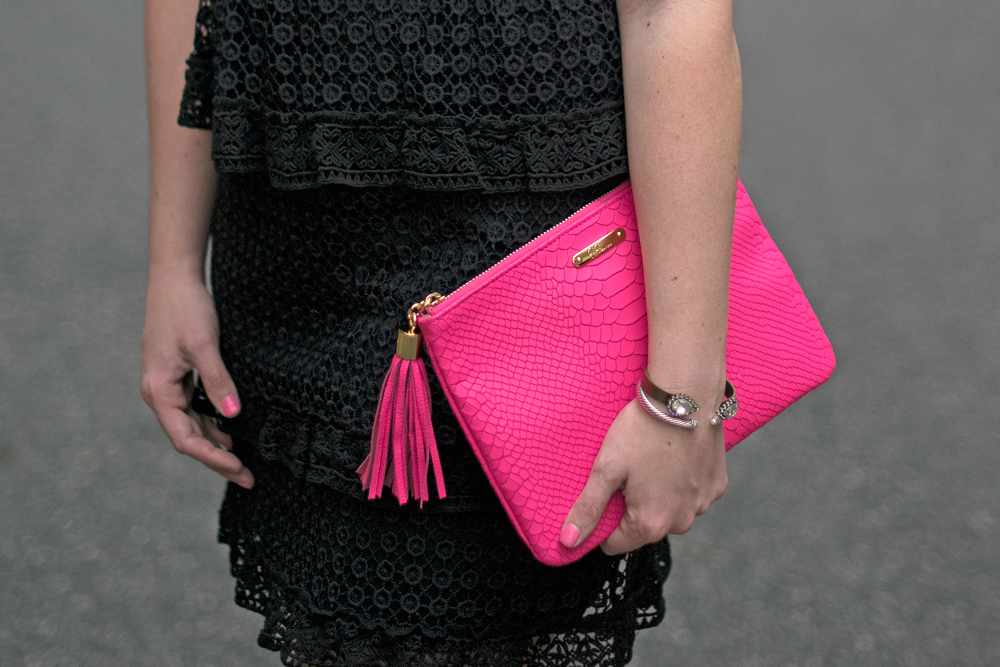 Black guest dress with pink clutch.