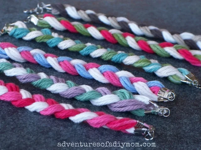 Rows of yarn bracelets on a chalkboard background