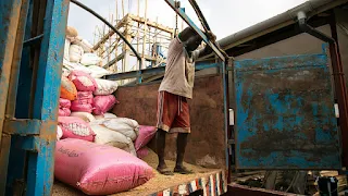 A worker at the Fabrar Rice Liberia Processing Plant rests before beginning the arduous task of unloading more than one hundred rice bags.