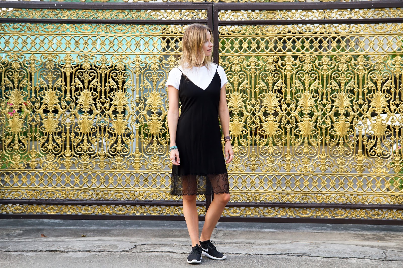 Fashion blogger, Alison Hutchinson, is wearing a white t-shirt under a black slip dress.