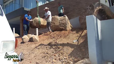 Bizzarri fazendo a execução do paisagismo com pedras com a máquina munck fazendo a colocação das pedras para fazer os canteiros sendo pedras ornamentais do tipo pedra moledo. 7 de março de 2017.