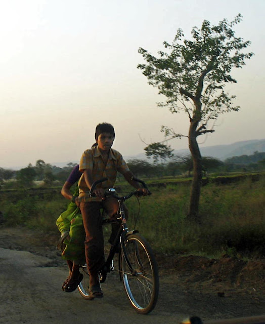 boy ferrying mom on bicycle