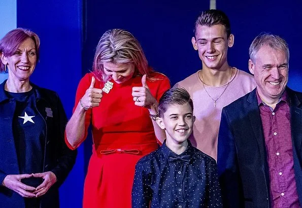 Queen Maxima wore a red dress by Vermeulen van Natan. The agreement is part of the program of The More Music in Classroom