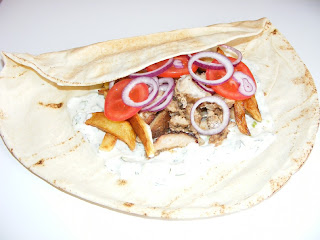 Retete mancare traditionala greceasca de tip fast food reteta gyros servit la farfurie tortilla sau lipie cu sos tzatziki cartofi prajiti si salata,