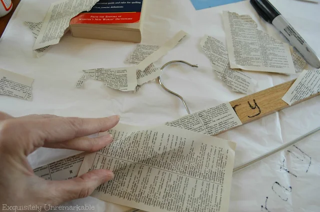 Covering a wooden hanger with book pages