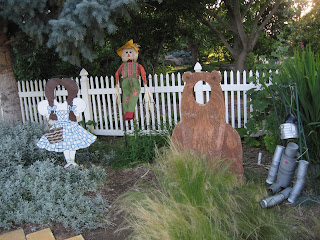 Dorothy and brown bear decorations with cut-outs for face. Scarecrow, Tin Man made from cans.