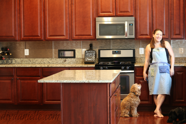 Backslash in brushed nickel with cherry cabinets and stainless steel appliances Fasade Brushed Nickel Ripple Backsplash
