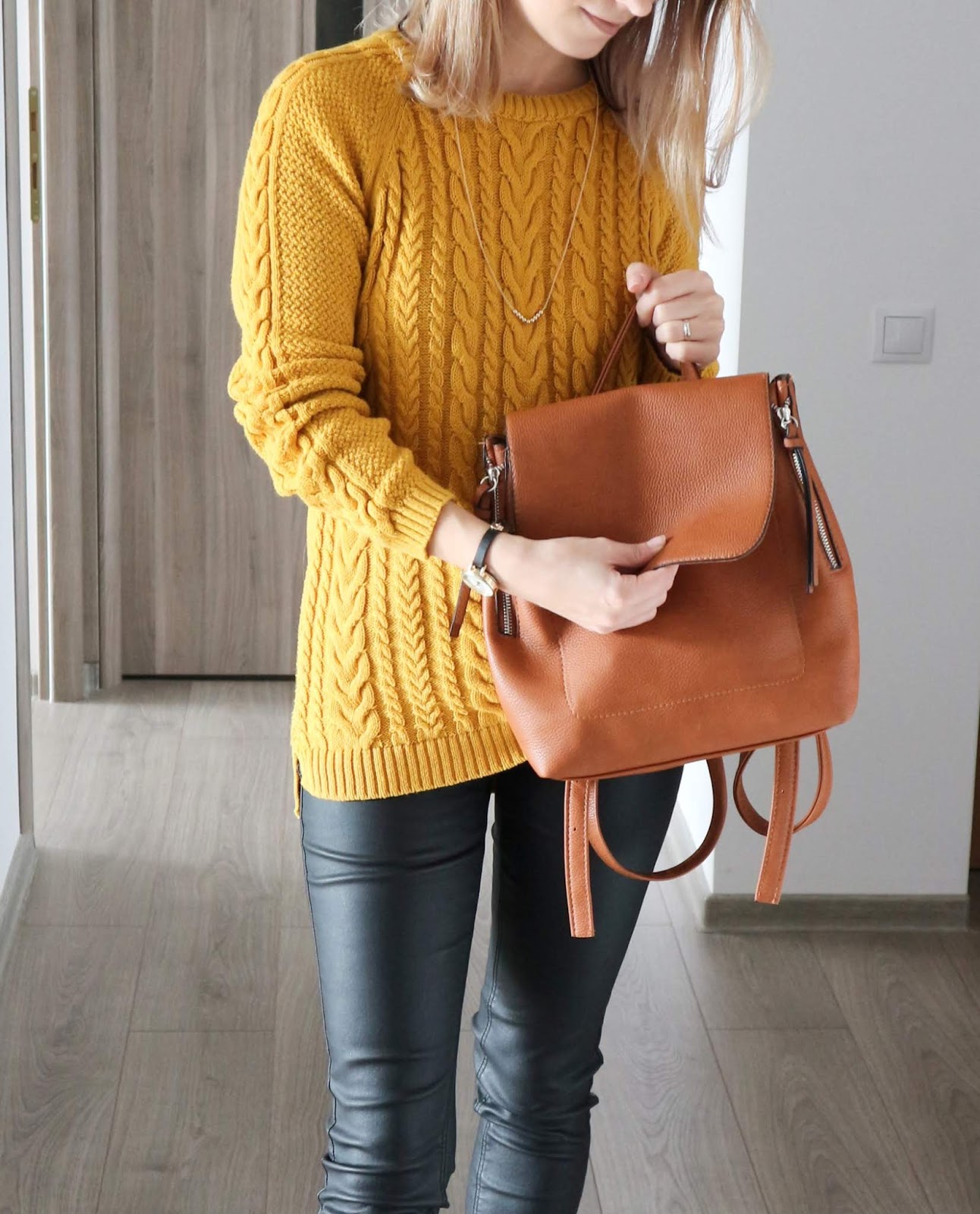cosy knit with tan backpack and coated jeans