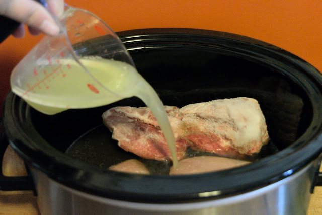 Lime juice being poured over the frozen pork chops in the slow cooker. 