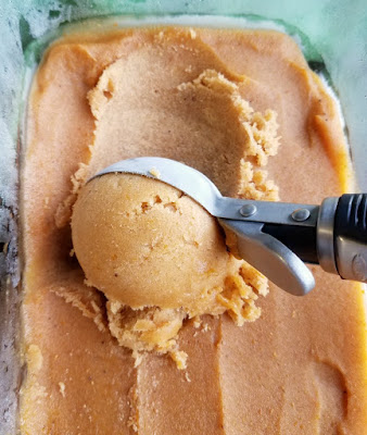 Have your pumpkin in a healthy ice cream form! This dairy free, healthy frozen treat is a great way to use ripe bananas and get your pumpkin fix! scooping out a ball of pumpkin ice cream with scoop