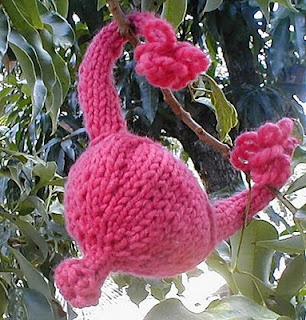 pink knitted uterus hanging out in a tree