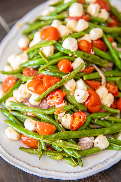 Italian Green Bean Salad - quick and delicious side dish! Green beans, tomatoes, garlic, olive oil, prosciutto, and mozzarella tossed in lemon juice and olive oil. Can serve hot or cold. Great for potlucks and cookouts. Can make in advance and refrigerate until ready to serve. Everyone always asks for the recipe! YUM! #salad #greenbeans #vegetable Italian Green Bean Salad - quick and delicious side dish! Green beans, tomatoes, garlic, olive oil, prosciutto, and mozzarella tossed in lemon juice and olive oil. Can serve hot or cold. Great for potlucks and cookouts. Can make in advance and refrigerate until ready to serve. Everyone always asks for the recipe! YUM! #salad #greenbeans #vegetable