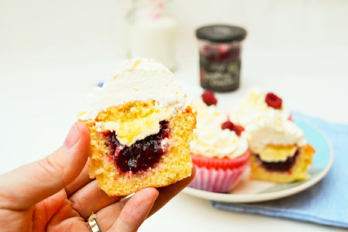 Close up of filled Vanilla Cupcakes with Clotted Cream and Raspberry Jam, cut in half