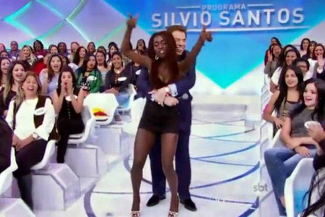 Foto de Silvio Santos agarrando moça da plateia