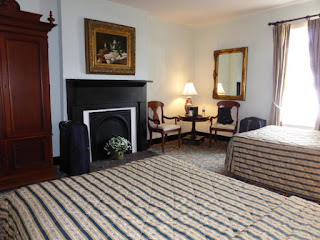 An inside image of the bedroom of St. James Hotel, Selma, Alabama with fireplace and two queen size beds in it 
