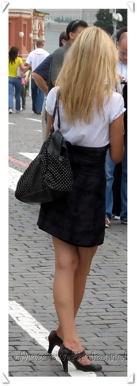 Slim blonde girl in black skirt (crossed legs)