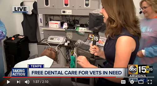snapshot of ABC 15 video with reporter Jamie Warren interviewing veteran John Hulett, who is being prepped for a denture procedure.