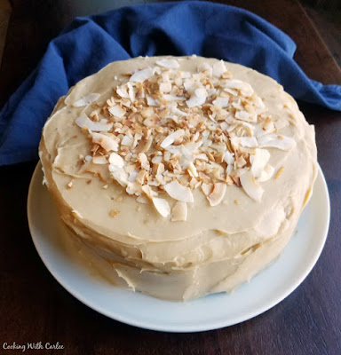 This creamy caramel frosting comes together really easily and starts with a can of sweetened condensed milk to make it extra special. It is a great way to make a caramel frosting for your favorite cakes! layer cake with sweetened condensed milk frosting topped with toasted coconut