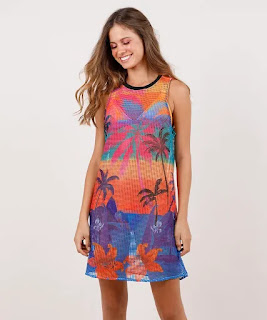 Moda Verão saída de praia feminina blueman em tela estampada poente tropical azul Saída de praia feminina desenvolvida em tela. A estampa Poente é colorida e tropical como a Blueman, ilustrando o fim de tarde na praia.