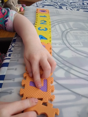 Toddler putting together the number puzzle
