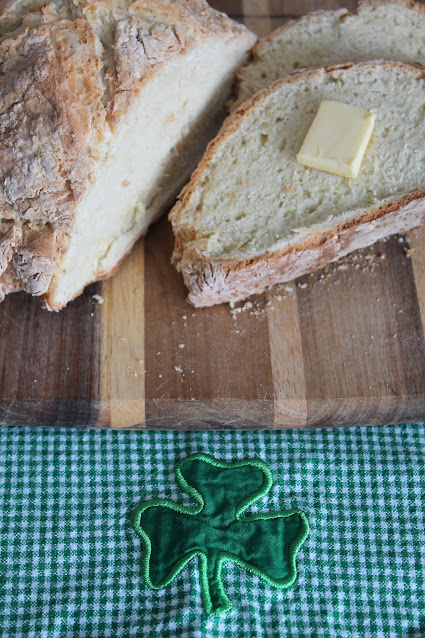 A loaf of Irish soda bread with some sliced.
