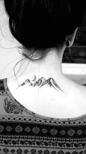 A lua paira sobre um mountainscape neste tatuagem.