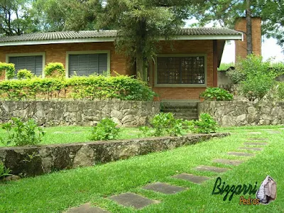 Execução do caminho do jardim com pedra folheta de granito tamanho 40x60 cm com os muros de pedra, a casa de tijolo a vista em sítio em Bragança Paulista-SP.