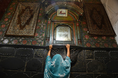 A Kashmiri Muslim woman embraces an inner wall of the 600-year-old shrine of Syed Mir Ali Hamdani, during the annual Urs in downtown Srinagar.