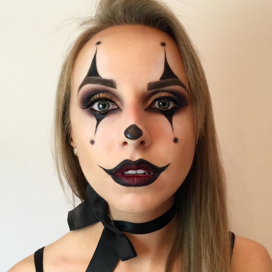 Clown makeup with an aqua and black face stripe