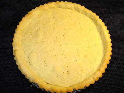 TART SHELL PORTIONS: 1 Shell (12 Portions) INGREDIENTS                                  ½ cup confectioner sugar 1 ½ cups all purpose flour 1/4 lb unsalted butter 2 egg yolks PREPARATION FOR TART SHELL In the food processor combine, sugar, flour, butter and egg yolks. Mix just enough to be able to form a ball. Place the dough in the refrigerator for about half hour. In a tart pan, about 10" in diameter and removable bottom, extend the dough, pressing with your fingers at the bottom and to the sides of the pan. Make sure you press well against the indentations of the tart pan.  If you prefer, you can dust  with flour the preparation table or parchment paper, and roll out the dough. Place the dough in the tart pan and follow the instructions given before. Puncture the dough with a fork. Place the dough in the freezer for 15 minutes before cooking Cook the tart in a preheated oven at 350° F - 176° C for about 13 minutes, lightly browned. Let it cool.