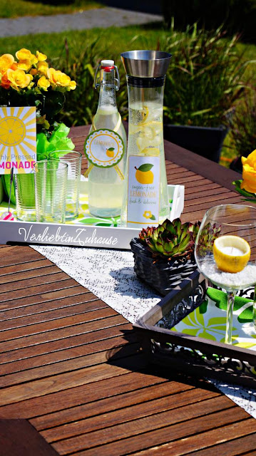 summer in the garden: decorated table with lemon candles and handmade lemonade