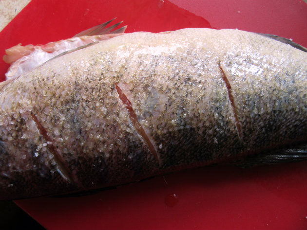 Pečeni smuđ sa začinskim travama 2 korak pripreme Baked perch with herb stuffing by Laka kuharica: cut three slashes into the thickest part of the fish on both sides.