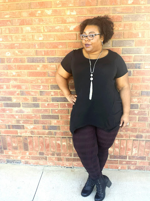 Gothic inspired, black tunic, printed bottoms, stacked heeled boots, tassel necklace, natural afro hairstyle