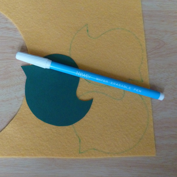 Yellow felt fabric with cardboard bird template fabric marker pen tracing design