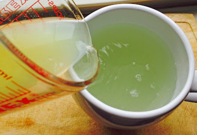 Lime juice being poured into pitcher of water