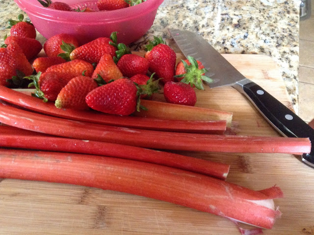 fresh Rhubarb and Strawberries on a cutting board