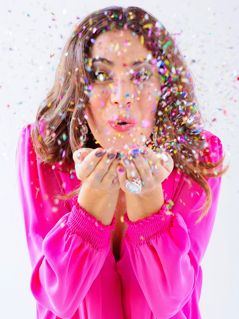 girl blowing confettit fashion editorial glitter christmas ootd pink