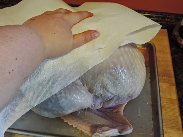 The rinsed turkey being patted dry. 