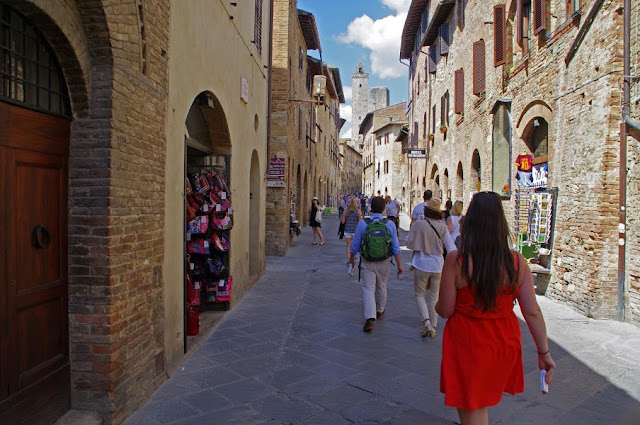 Girl walking through streets of San Gimignano Girl walking through streets of San Gimignano