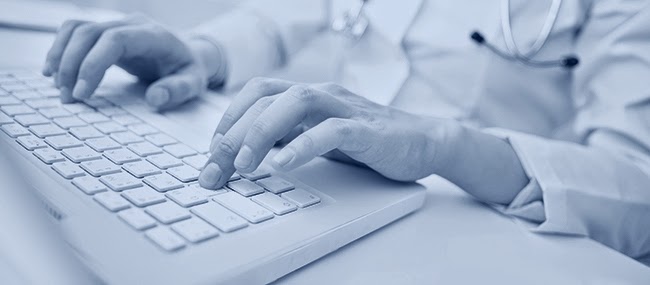 Foto de um homem digitando num teclado de computador