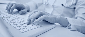 Foto de um homem digitando num teclado de computador