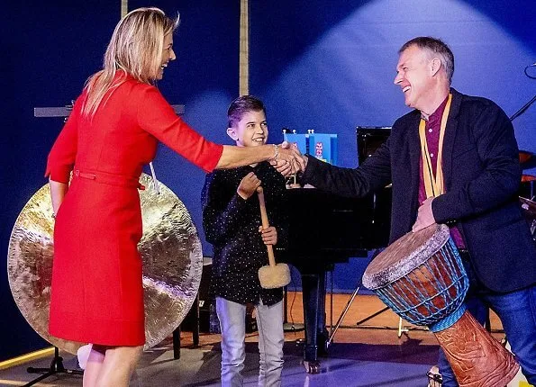 Queen Maxima wore a red dress by Vermeulen van Natan. The agreement is part of the program of The More Music in Classroom