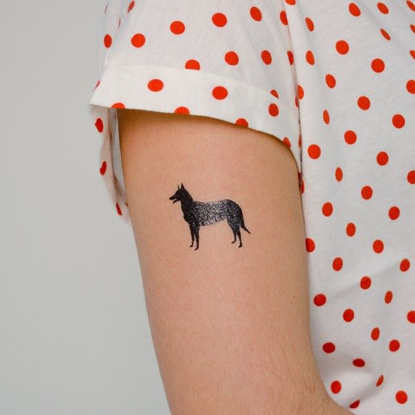 Imagen de un tatuaje temporal de pastor alemán e el brazo de una mujer