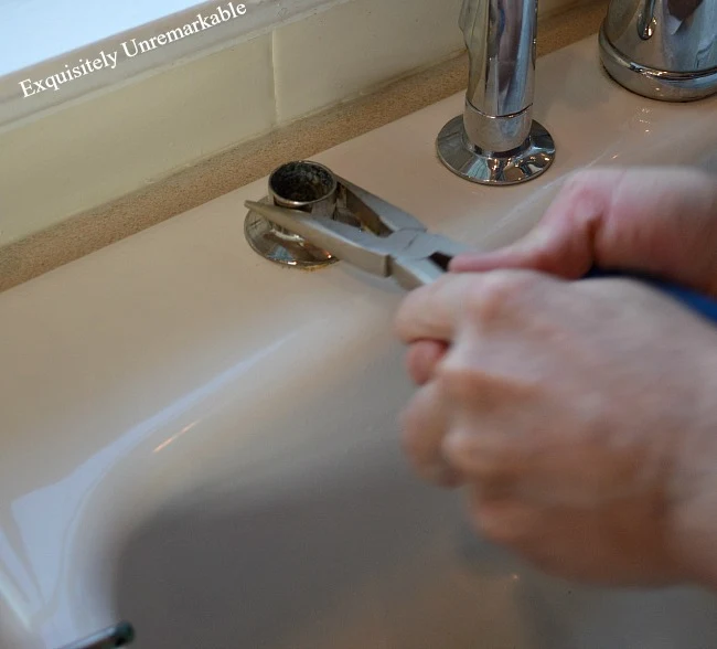 Using plier to twist sink pump base from sink